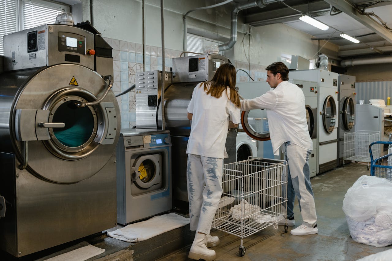Mastering the First Impression: Your intriguing post title goes here Two adults working in an industrial laundry facility with large machines.